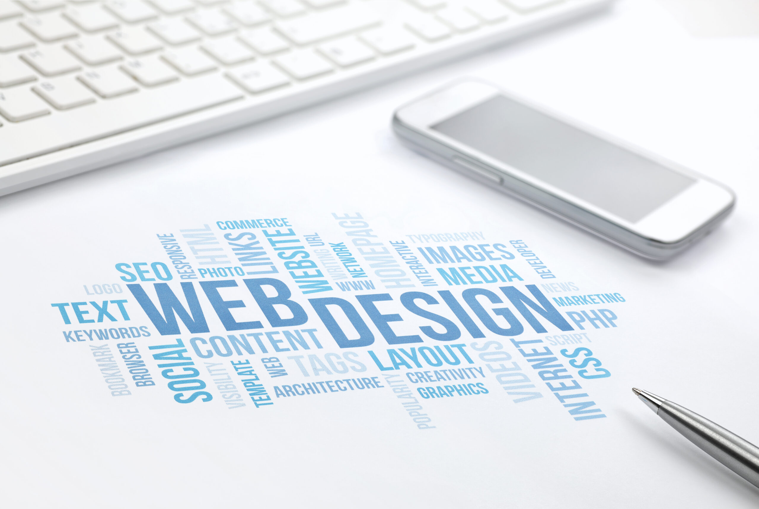 Web Design business concept word cloud print document, keyboard, pen and smartphone, keyboard, pen and smartphone. Blue toned.